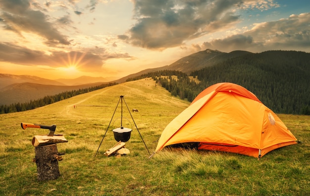 Premium Photo | Orange tent with a prepared bonfire at sunset