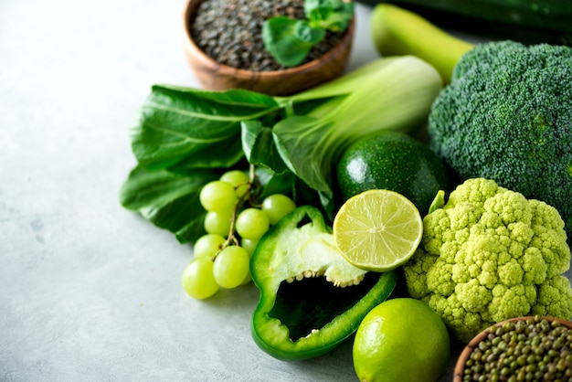 Premium Photo | Organic green vegetables and fruits on grey background.