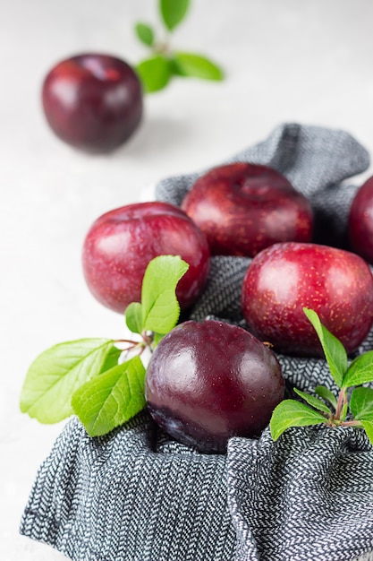 Premium Photo | Organic purple plums with leaves