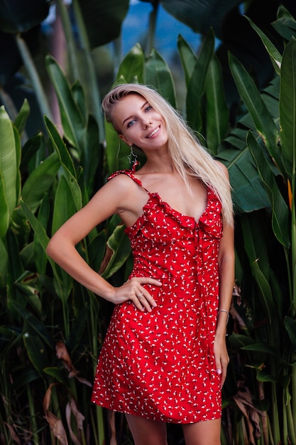 アウトドアファッションの肖像画自然の美しさライトメイク スターイヤリング ブレスレット リングを持つ若いきれいな女性 赤い夏の花のドレスの女性 無料の写真