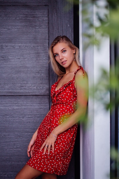 アウトドアファッションの肖像画自然の美しさライトメイク スターイヤリング ブレスレット リングを持つ若いきれいな女性 赤い夏の花のドレスの女性 無料の写真