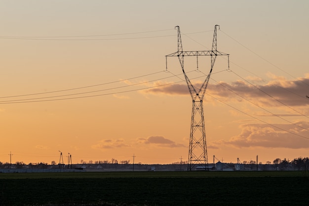 Overhead power line in the countryside at sunset Free Photo