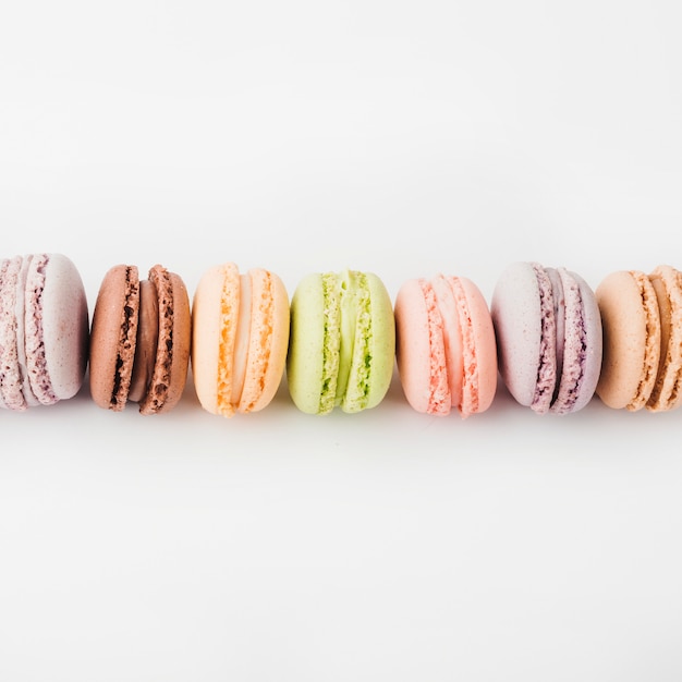 An overhead view of colorful macaroons against white background Photo ...