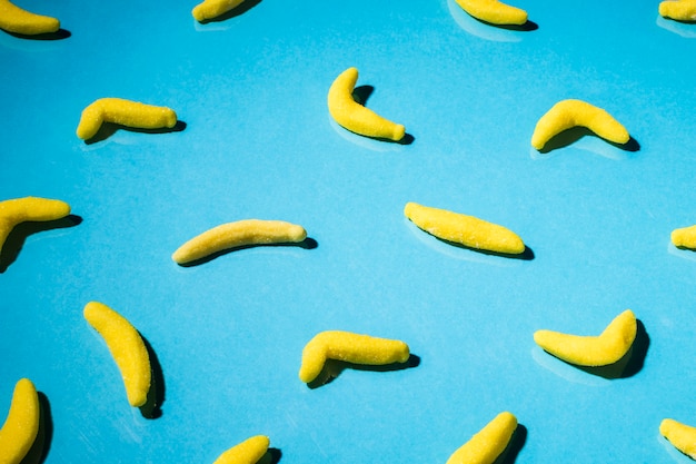 青色の背景にグミのバナナキャンディーのオーバーヘッドビュー 無料の写真