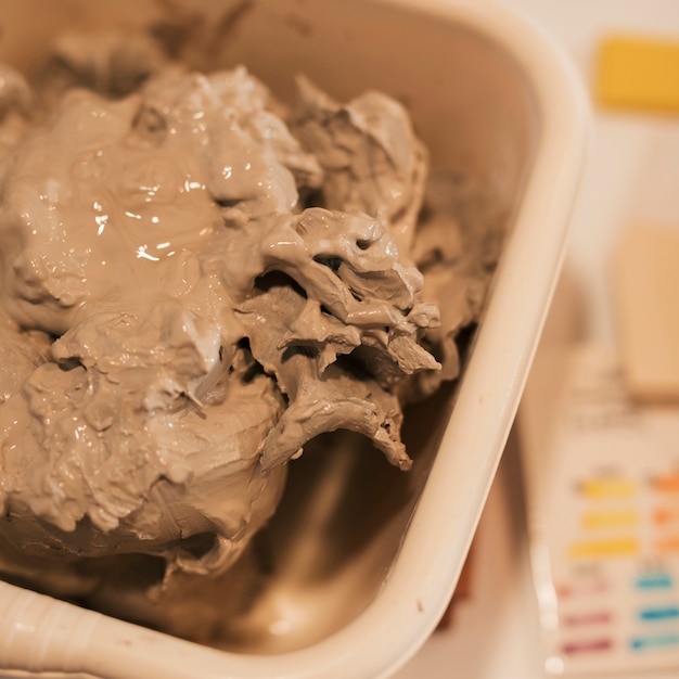 An overhead view of wet clay in the container | Free Photo