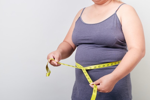 彼女の脂肪の腹を測定太りすぎの女性 プレミアム写真