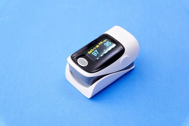 Premium Photo | Oximeter on blue background, copy space