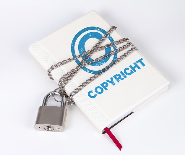 A padlock protects the book in a concept with copyright text and symbol Premium Photo