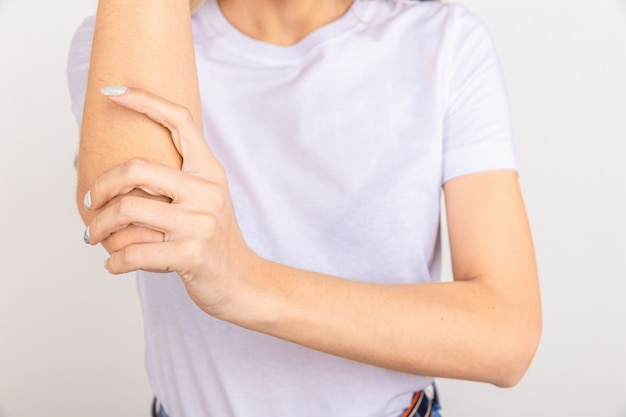 Premium Photo | Pain in hand, girl holds her cubit on white. sore elbow ...