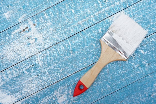 Premium Photo | Paint brush on blue wood floor