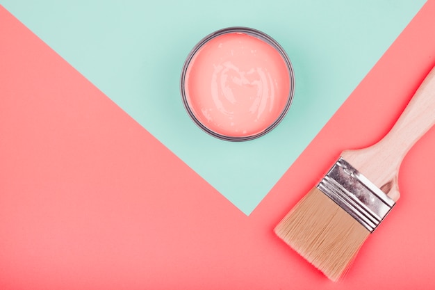 Paint can and paintbrush on mint and coral dual backdrop Free Photo