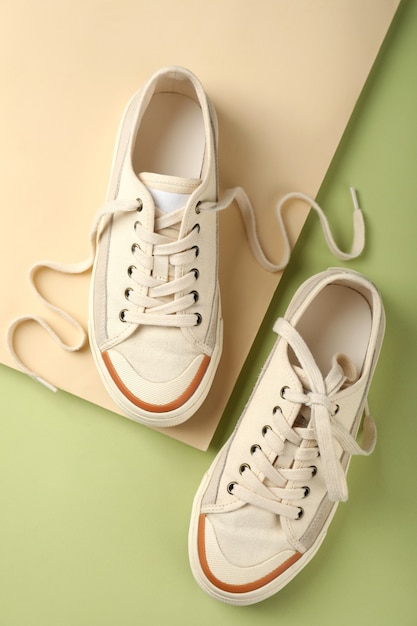 Premium Photo | Pair of beige sneakers on two tone background