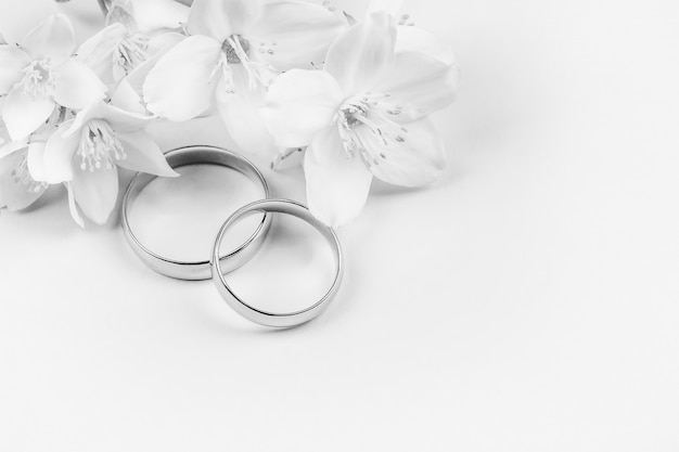 Pair of gold  wedding  rings  and white  jasmine flowers on 