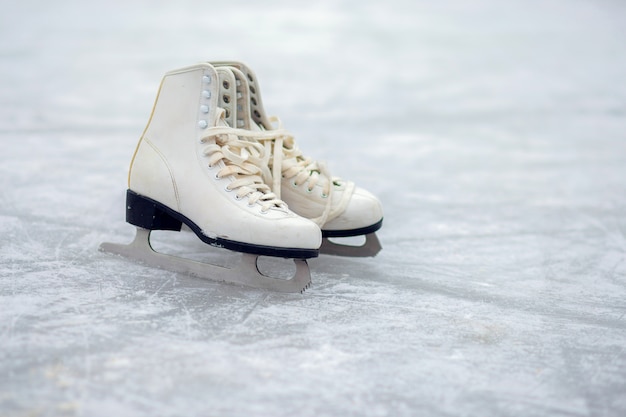 Premium Photo | A pair of white figure skates are standing on an open ...