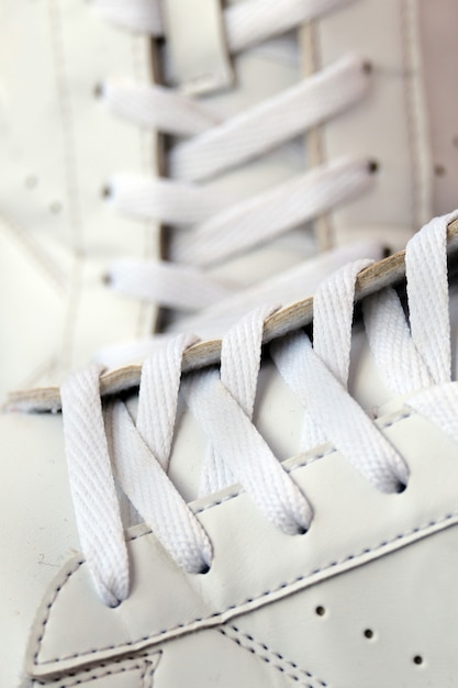 Premium Photo | Pair of white used sneakers with shoelaces closeup