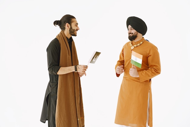 民族衣装を着たパキスタン人男性とインド人男性 友達は 孤立した白い背景で話しています 国同士の仲裁 無料の写真