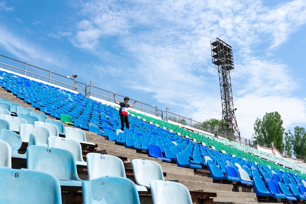 Premium Photo | Panorama of huge stadium seats with a man watching the ...