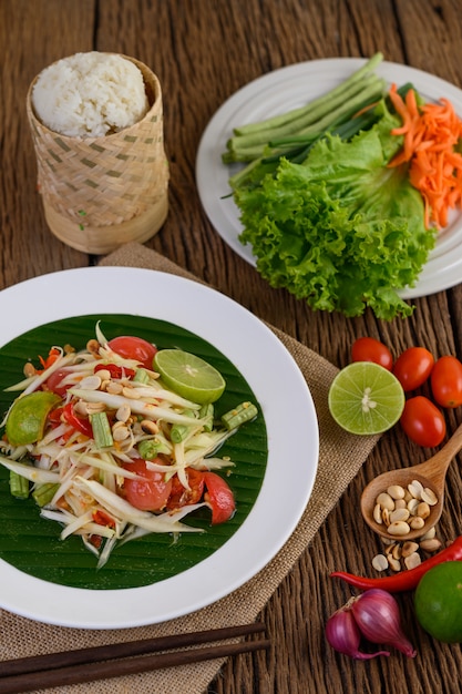 Free Photo | Papaya salad (som tum thai) on a white plate on a wooden ...