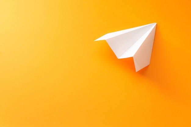 Premium Photo | Paper plane on an orange background