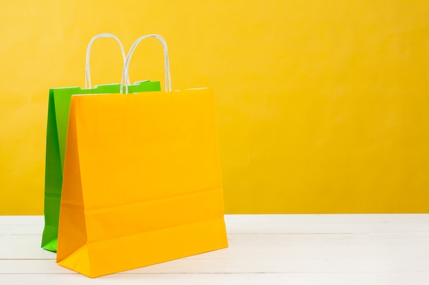 Download Premium Photo Paper Shopping Bags On Bright Yellow Background PSD Mockup Templates