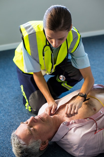 Premium Photo | Paramedic using an external defibrillator during ...