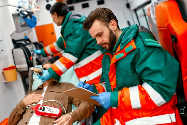 Premium Photo | A paramedic woman in uniform puts on a ventilator with ...