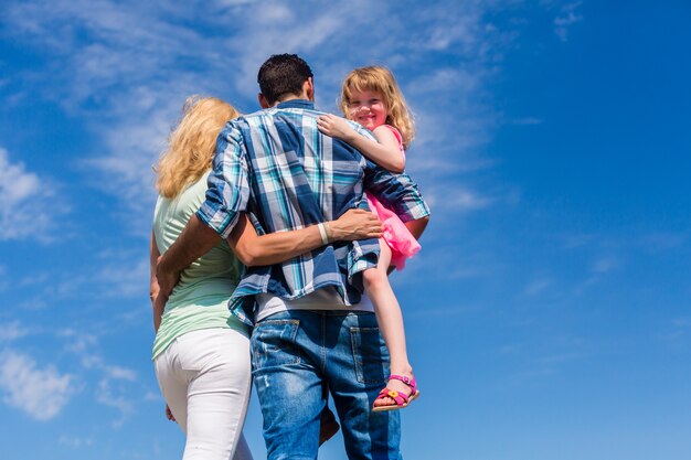 Premium Photo | Parents and daughter, arm in arm in back view