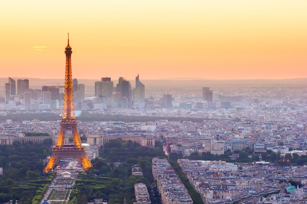 Paris- july 9 : skyline of paris with eiffel tower from above in orange sunset twilight, on july 9, 2015 in paris france Premium Photo