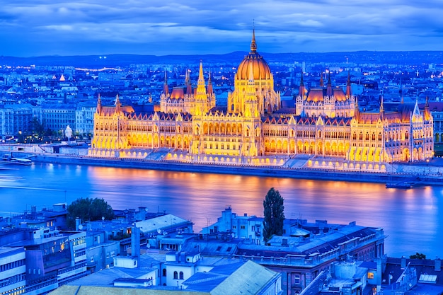 議会とハンガリーブダペストの青の時間日没時に川沿い プレミアム写真