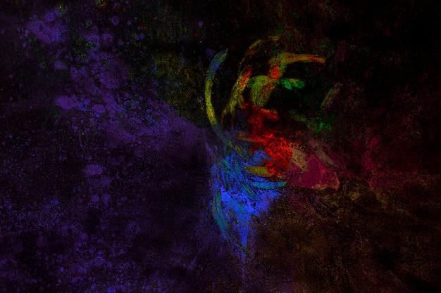 黒の背景に手と混合されたホーリー色の粒子 プレミアム写真
