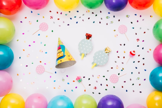 Party Hat And Horn Blower Decorated With Colorful Balloons And Confetti 