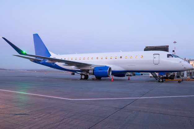 Premium Photo | A passenger aircraft parked by the boarding bridge