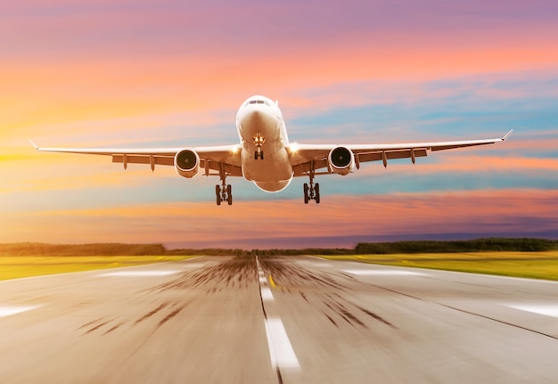 Premium Photo Passenger airplane landing at sunset on a runway Premium Photo Passenger airplane landing at sunset on a runway