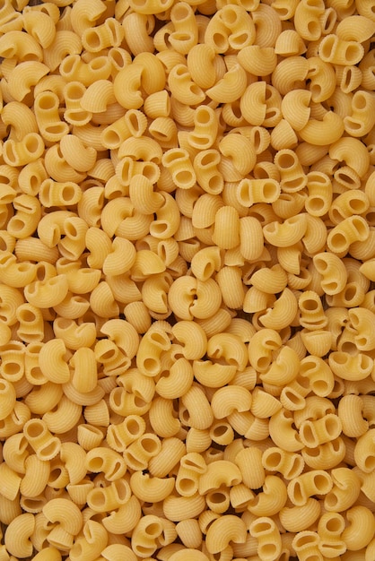 Premium Photo | Pasta concept the large amounts of dry yellow tubular ...