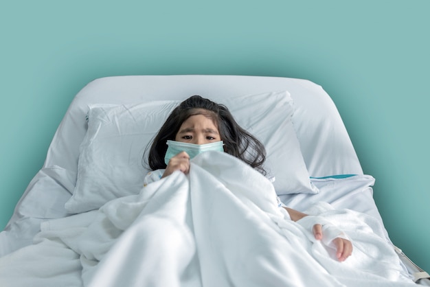 Premium Photo | Patient asian kid with mask have fever on hospital bed