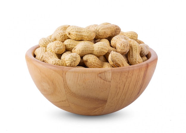 Premium Photo | Peanuts in wood bowl on white wall.