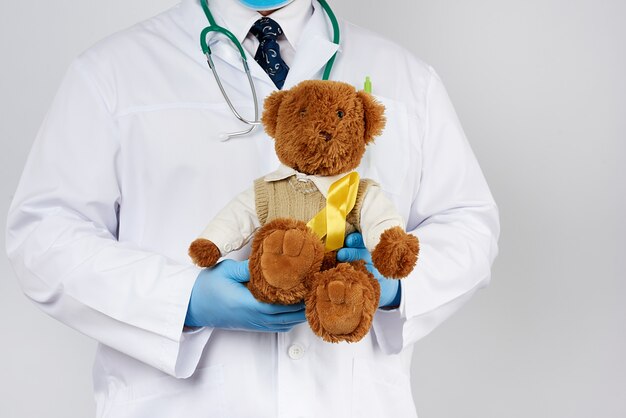 Premium Photo | Pediatrician in white coat, blue latex gloves holds a ...