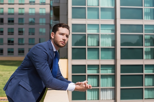 Pensive Business Man Leaning On Railing Outdoors Photo Free Download