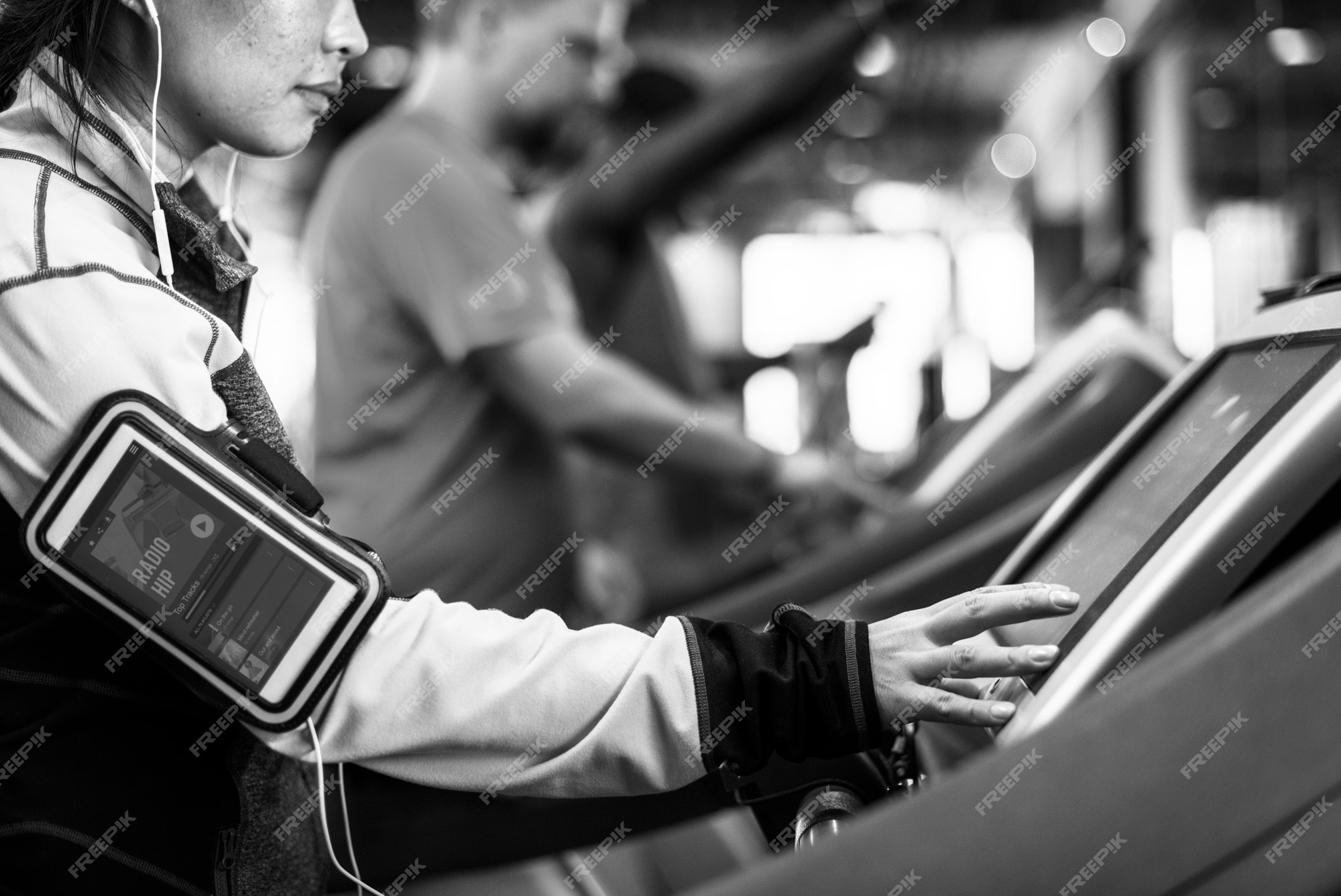  A black and white image of a person using a treadmill at a gym while listening to a podcast about enhancing creativity.