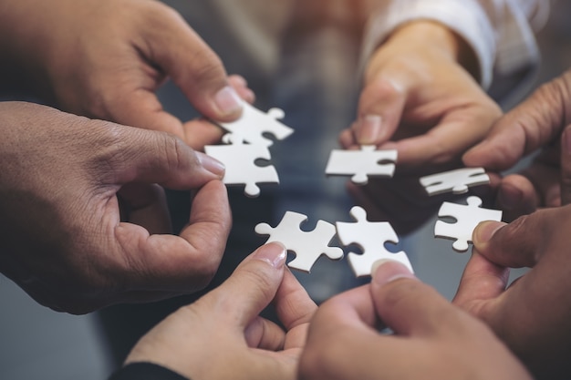 Premium Photo | People hands holding a jigsaw puzzle in circle together