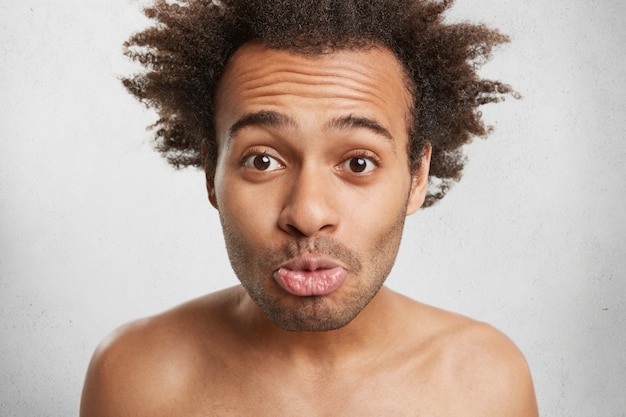 人 人間の表現と感情の概念 アフロの髪型を持つ面白い暗い肌の男性は一人で愚かです 無料の写真
