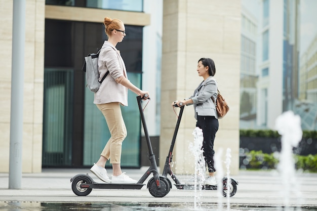 People riding electric scooters in city | Premium Photo