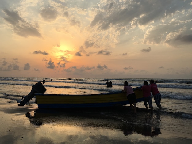 People on sea beach at sunset having fun Premium Photo