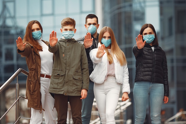 People wearing protective masks are showing stop sign by hands Free Photo