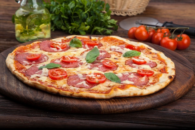 Premium Photo | Pepperoni pizza with tomatoes and basil