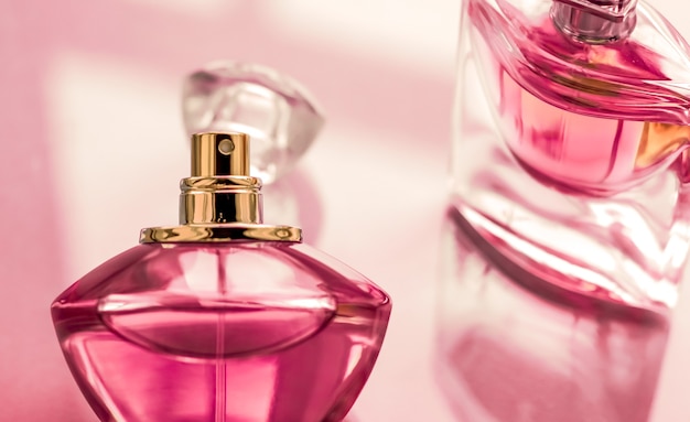光沢のある背景に香水スパとブランディングコンセプトのピンクの香水瓶甘い花の香りの魅力的な香りとホリデーギフトや高級美容化粧品のブランドデザインとしてのオードパルファム プレミアム写真