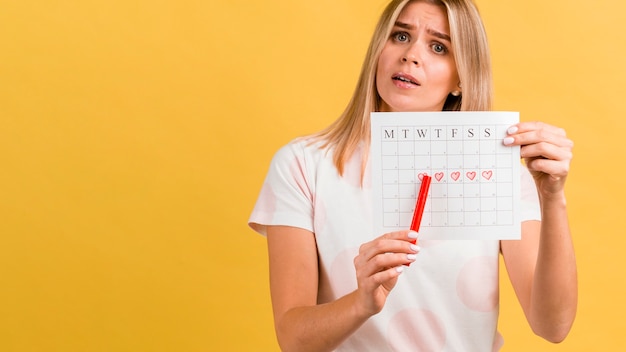 Period calendar with drawn heart shapes and woman | Free Photo