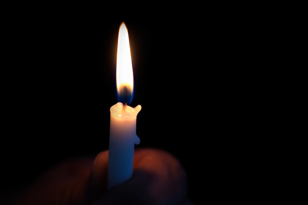 A person holding a candle in the dark | Premium Photo