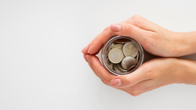 Person holding a jar with coins Free Photo