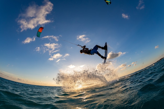 Person surfing and flying a parachute at the same time in kitesurfing. bonaire, caribbean Free Photo